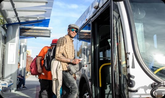 Rider at bus stop loading the bus