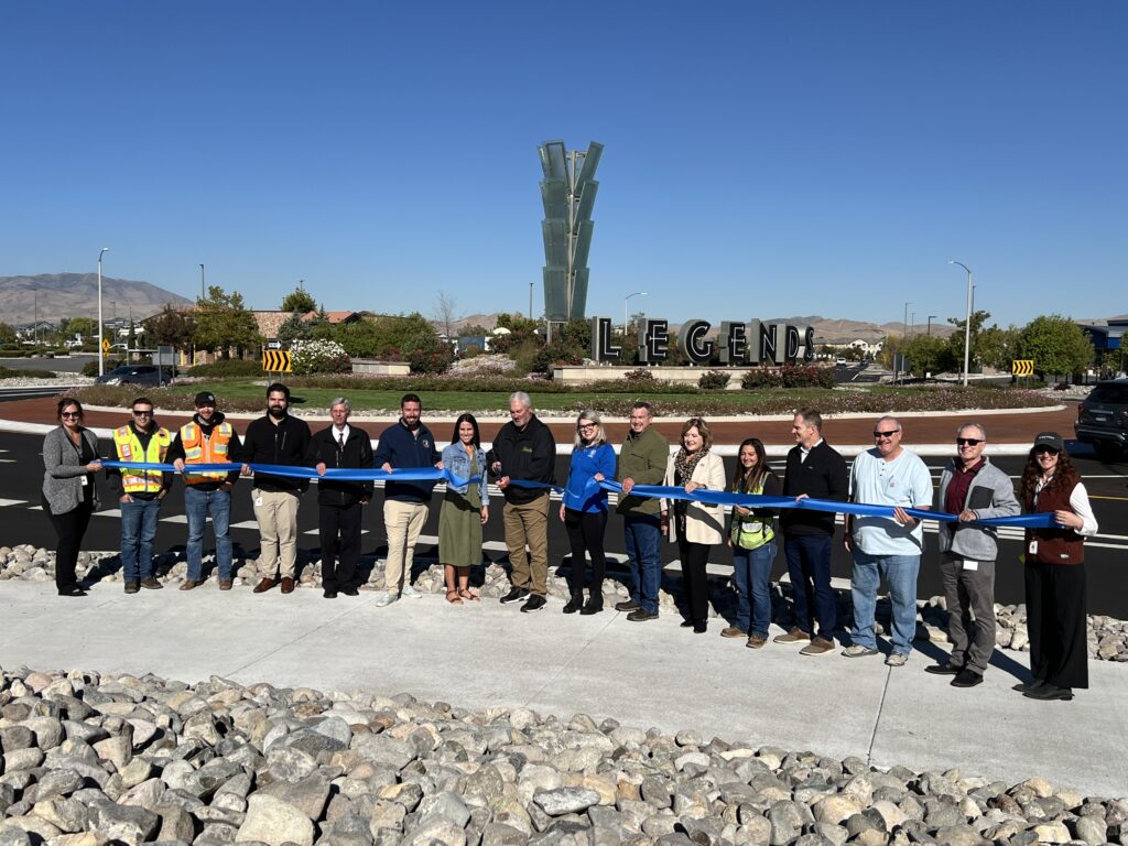 Group of staffers lined up cutting the ribbon on the new roundabout